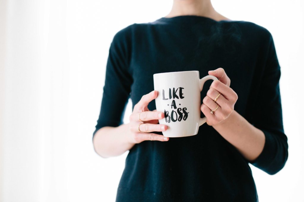 woman holding a "like boss" cup