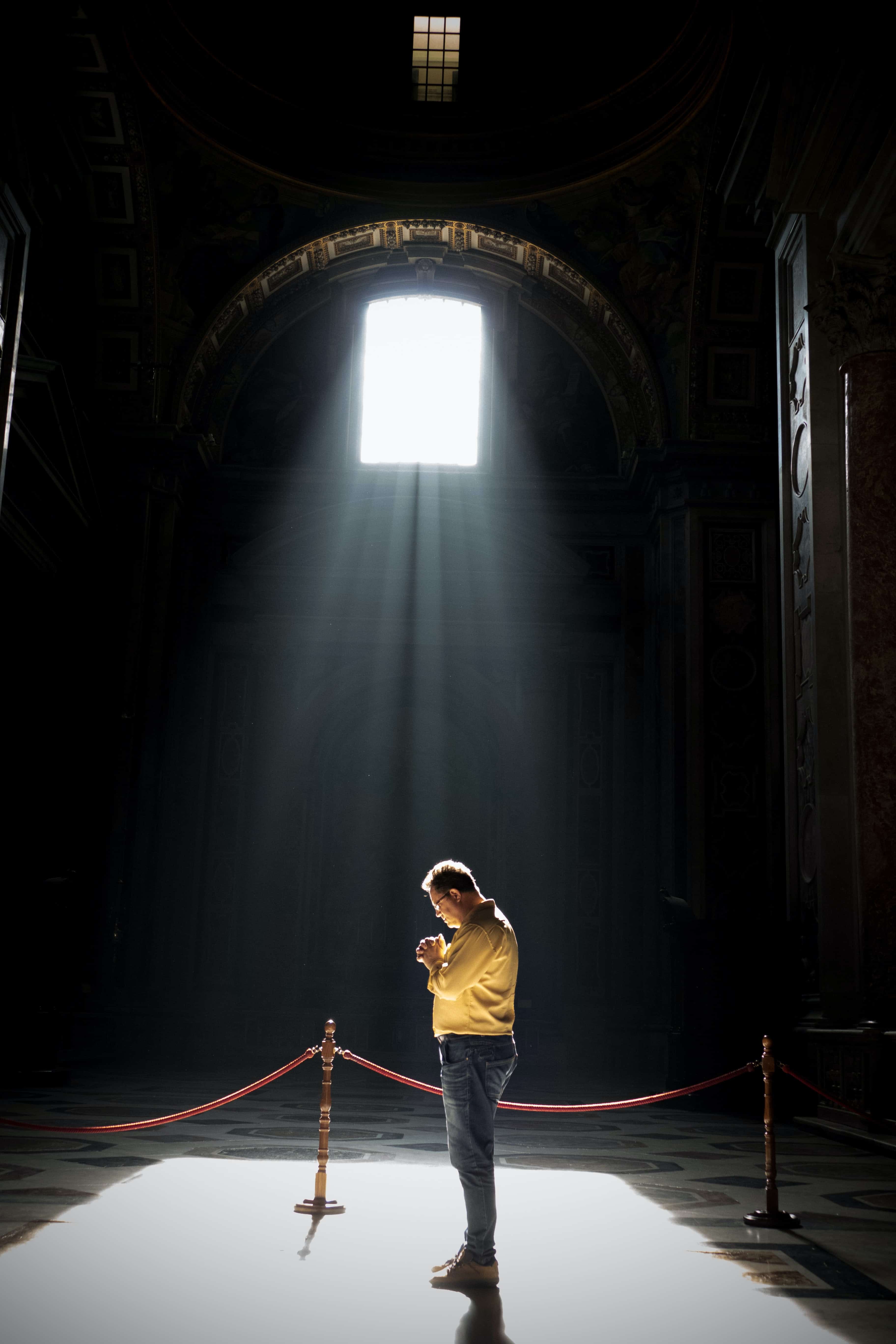man praying inside a church building.