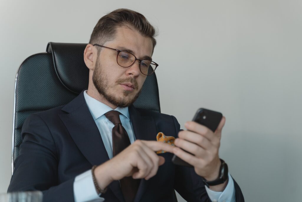 a man in suits checking his phone